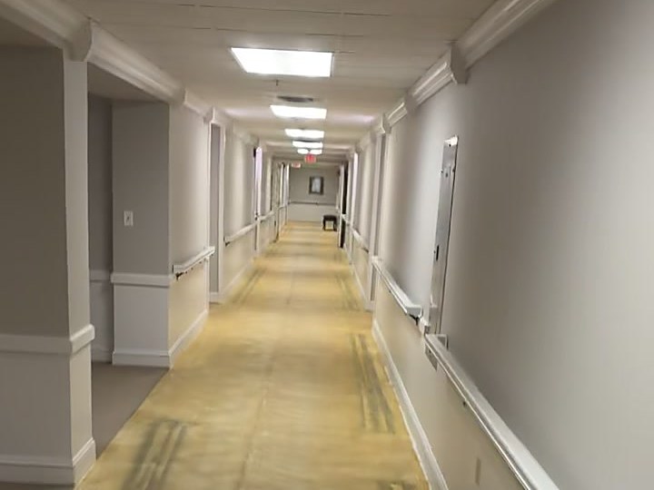 Long facility corridor with the old floor stripped out end to end