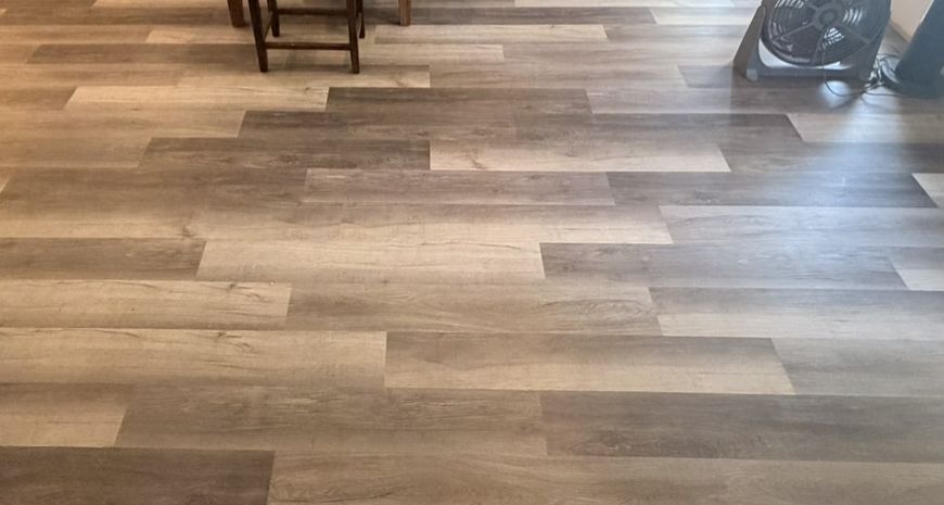 Finished grey wood-look LVP across an open living and dining area