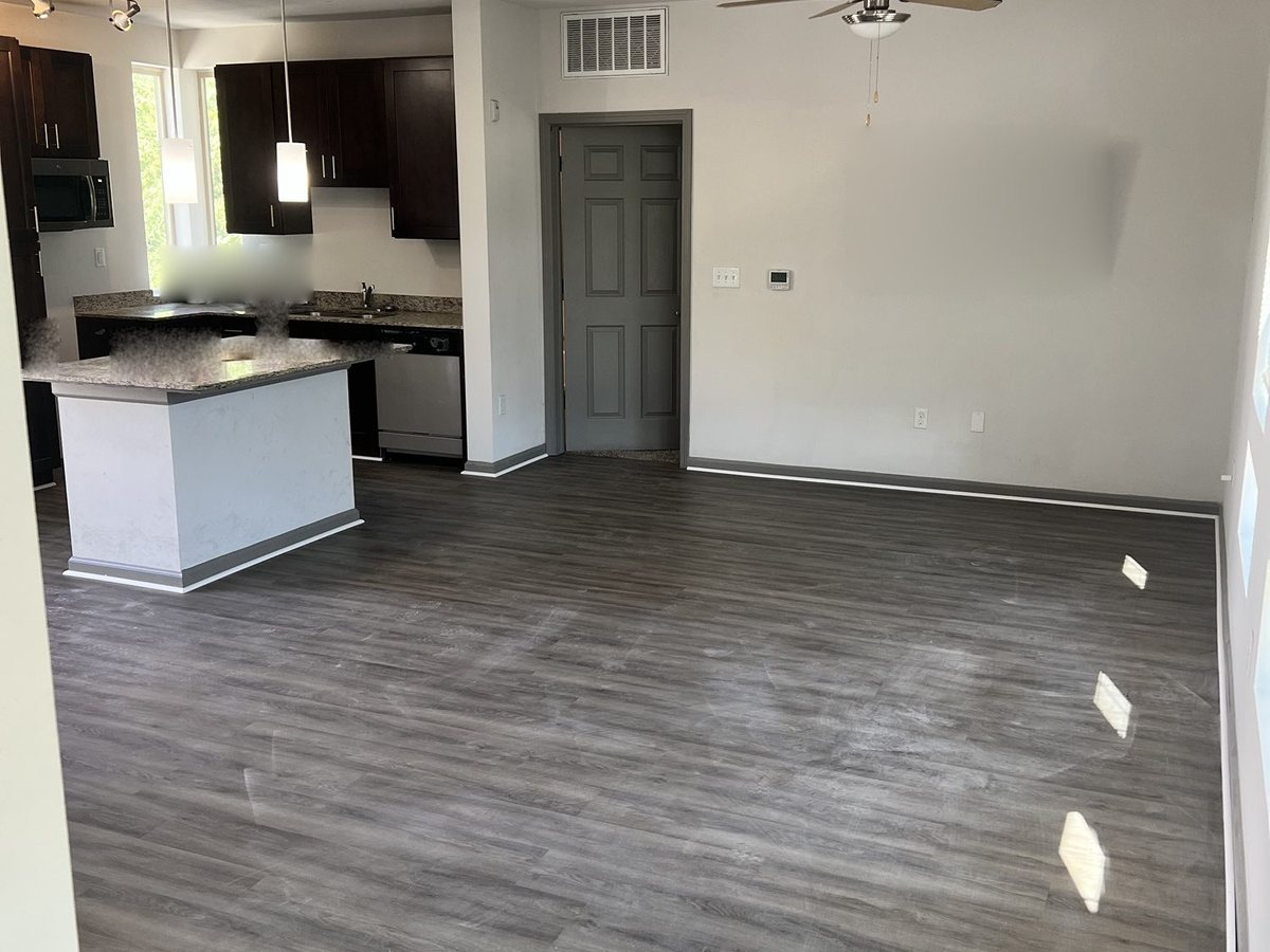 Living room finished in grey wood-look LVP, wall to wall