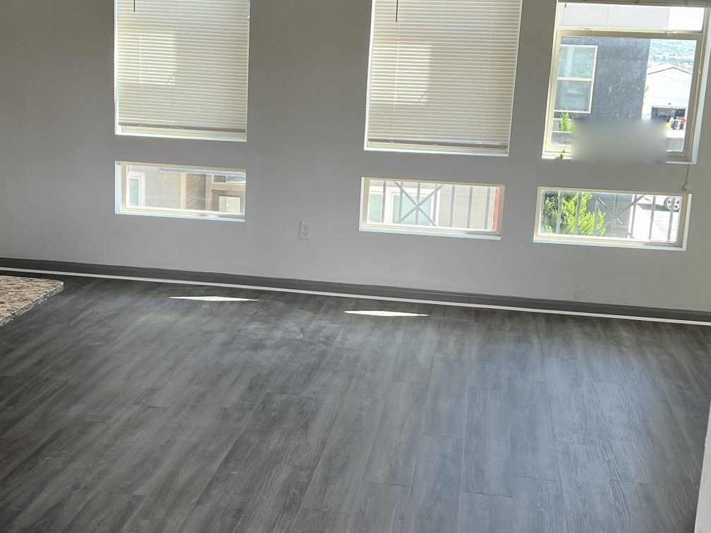 Multifamily unit finished in grey wood-look LVP, running to a wall of windows