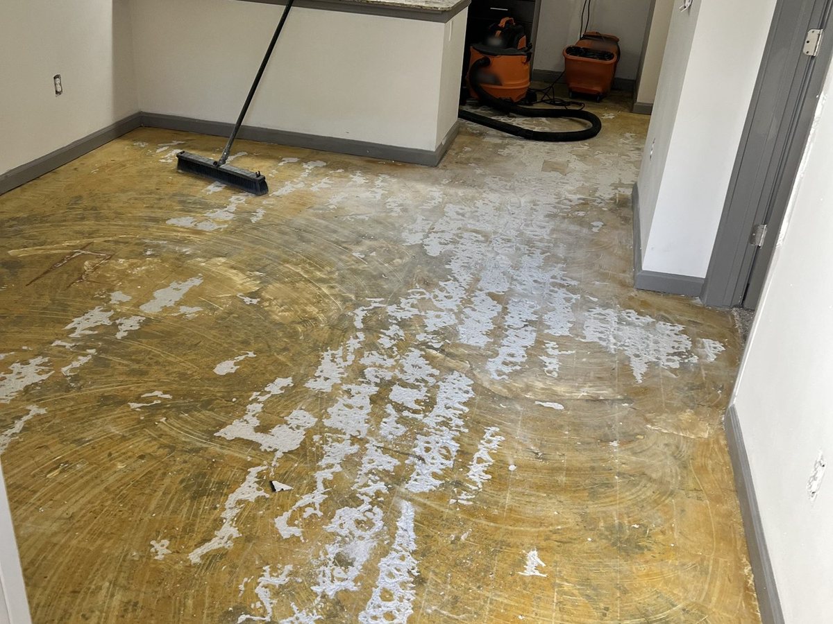 Apartment slab after the old adhesive was ground off, before leveling