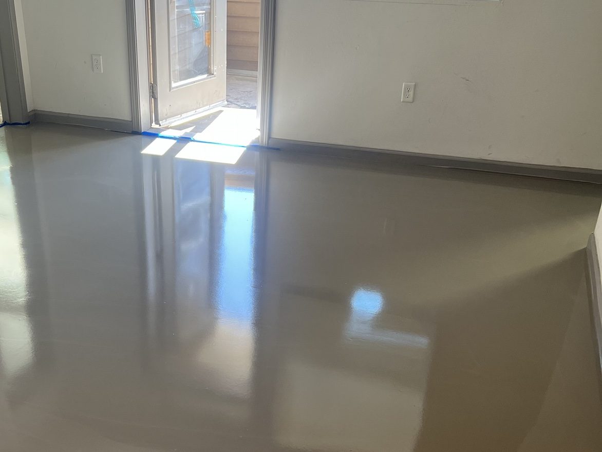 Fresh self-leveling underlayment poured glass-flat across the same apartment